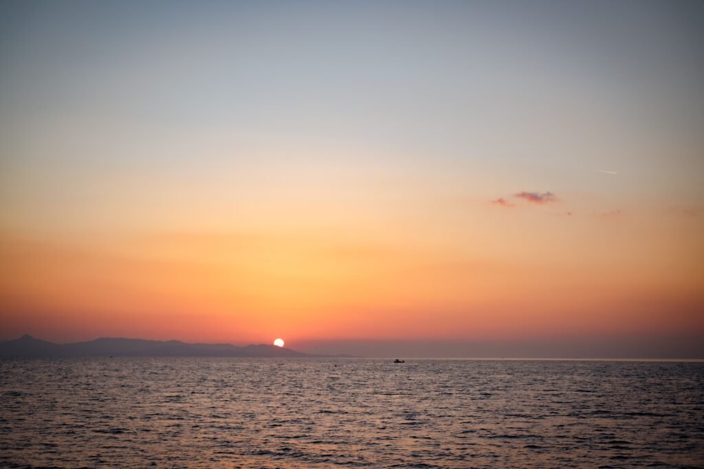 希腊爱琴海的暖色日落与海岸剪影